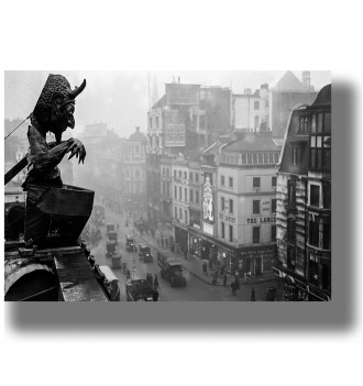 Black and white photo of a gargoyle above a London street with old buildings and cars below.