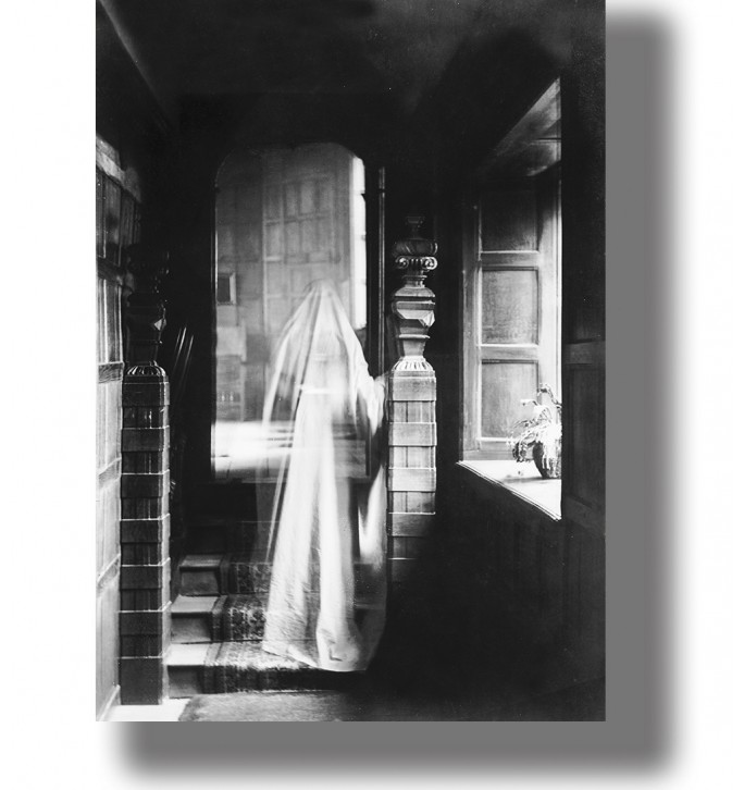 Vintage black and white photo of a ghostly figure standing in a dark hallway.