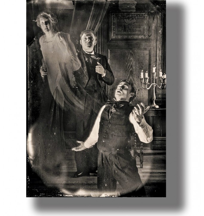 Old black and white séance photo with a ghostly figure and two men in a theatrical spirit scene.