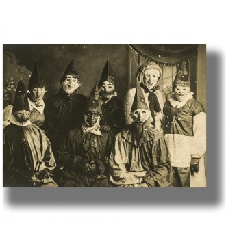 Vintage Halloween group photo with people in strange costumes, masks, and pointed hats.