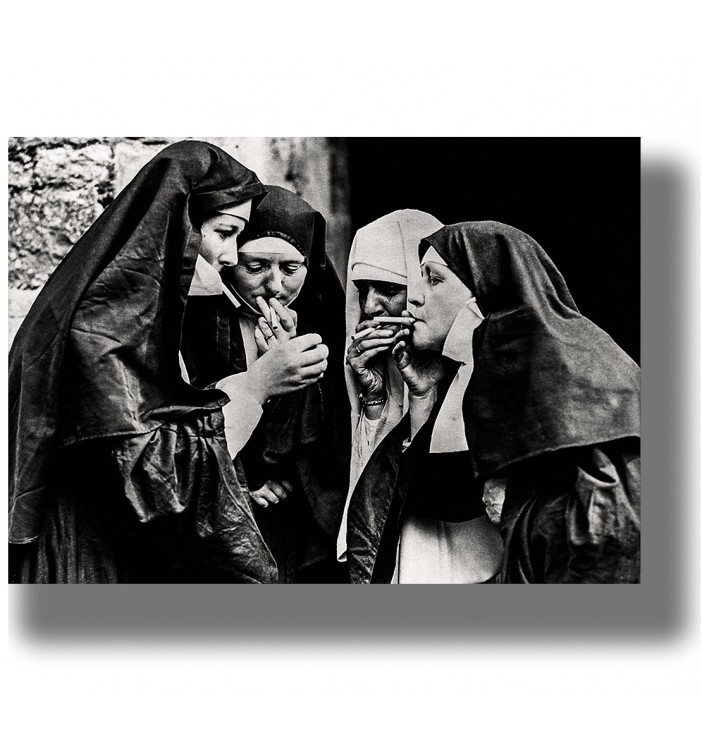Vintage black and white photo of four nuns lighting cigarettes together.