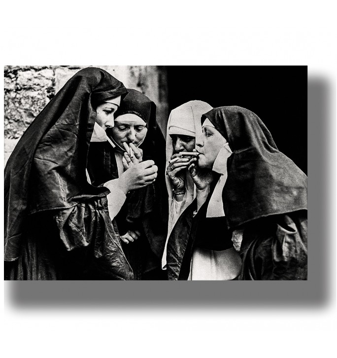 Vintage black and white photo of four nuns lighting cigarettes together.