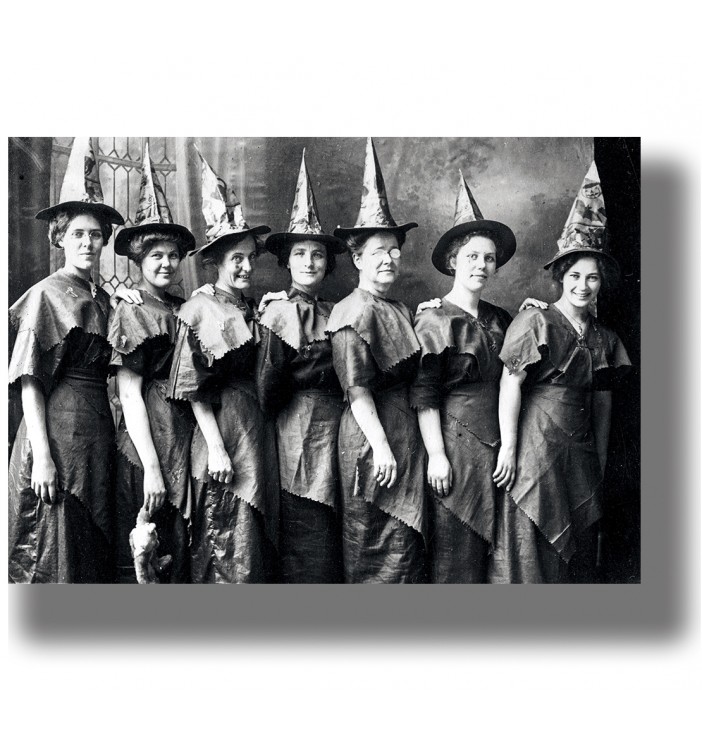 Old group portrait of women wearing pointed hats and similar dark dresses.