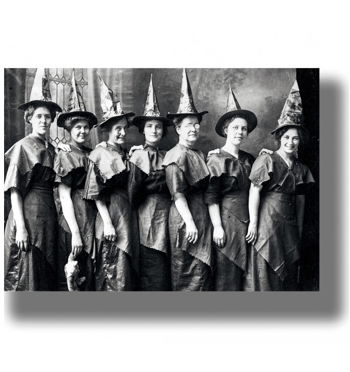 Old group portrait of women wearing pointed hats and similar dark dresses.
