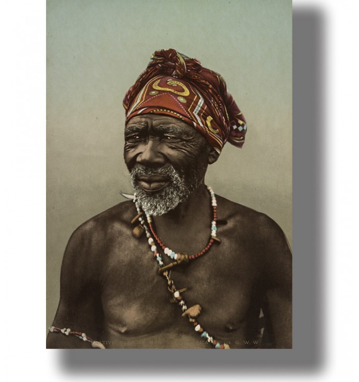 Older South African man wearing a patterned red headwrap and colorful beaded necklaces in a vintage portrait.