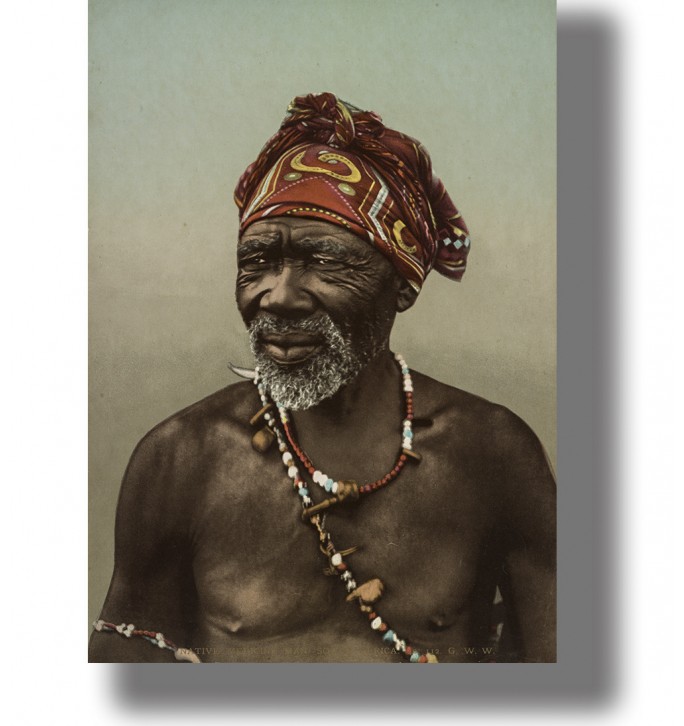 Older South African man wearing a patterned red headwrap and colorful beaded necklaces in a vintage portrait.