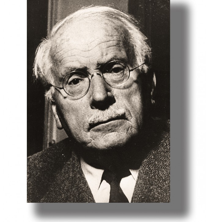 Vintage black and white portrait of Carl Gustav Jung wearing round glasses, a suit and tie.