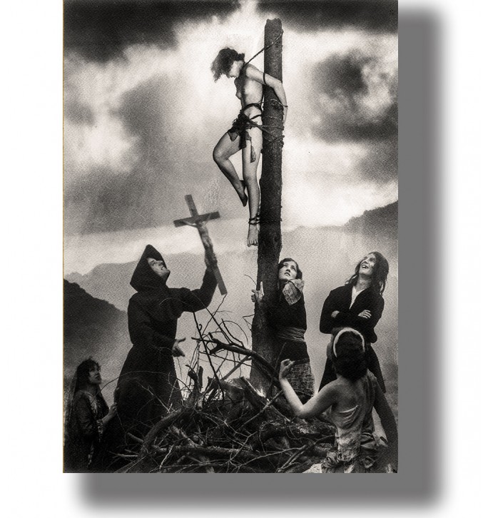 Black and white photograph showing a woman bound to a wooden post while dark figures gather below.
