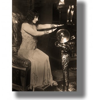 Vintage black and white photo of a woman with a crystal ball in an occult interior.