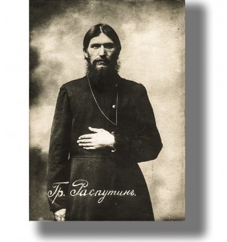 Old portrait of Grigori Rasputin standing in dark clothing with long beard and serious expression.