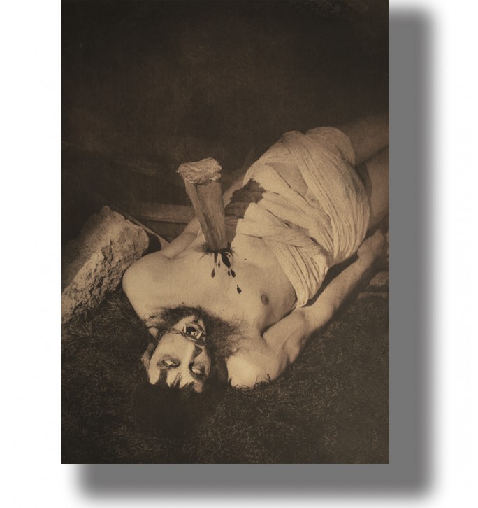 Dark vintage horror photo of a man with a stake in her chest in a staged gothic scene.