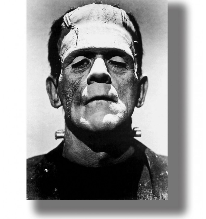 Black and white close-up of Frankenstein’s monster with a flat head, heavy features and bolts at the neck.