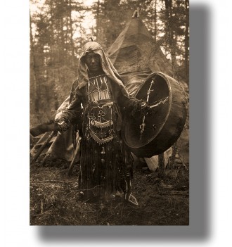 Black and white photograph of a Siberian shaman with a drum standing in a forest camp.